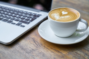 Bild einer Tasse Kaffee und eines Laptops.